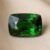 Natural cushion cut chrome tourmaline gemstone on soft beige fabric