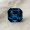 Natural emerald cut cobalt spinel gemstone on soft cream fabric