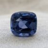 Natural cushion cut cobalt spinel gemstone on soft grey fabric