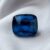 Natural cushion cut cobalt spinel gemstone on soft grey fabric