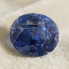 Natural oval cobalt spinel gemstone on soft cream fabric