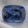 Natural cushion cut cobalt spinel gemstone on soft grey fabric