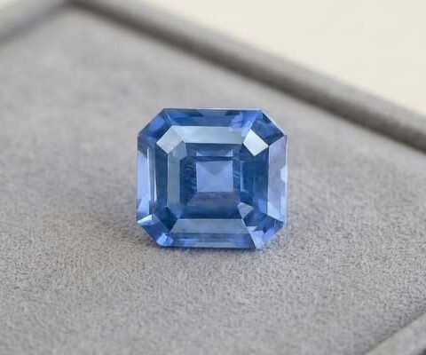 Natural octagonal cobalt spinel gemstone on soft grey jewelry display