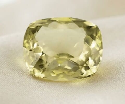 Natural cushion cut color change diaspore gemstone on soft cream fabric