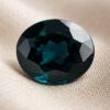 Natural oval color change garnet gemstone on soft beige fabric