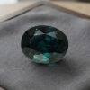 Natural color change garnet with GIA report on soft grey jewelry display