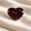 Natural heart shaped color change garnet gemstone on soft cream fabric
