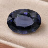 Natural oval color change spinel gemstone on soft beige jewelry display
