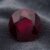 Natural oval East African ruby gemstone on dark grey fabric