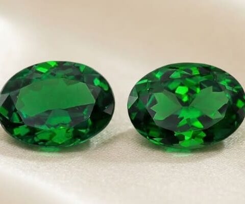 Natural oval tsavorite matching pair on soft cream fabric