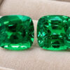 Natural cushion cut tsavorite matching pair with GIA report on beige jewelry display