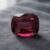 Natural cushion-cut garnet gemstone on dark grey fabric