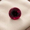 Natural round garnet gemstone on soft cream jewelry display