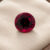 Natural round garnet gemstone on soft cream jewelry display