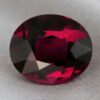 Natural oval garnet gemstone on soft grey fabric