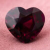 Natural heart shaped garnet gemstone on soft pink fabric