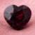 Natural heart shaped garnet gemstone on soft pink fabric