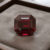 Natural emerald cut garnet gemstone on soft grey jewelry display