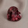 Natural heart shaped garnet gemstone on soft beige fabric