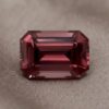 Natural emerald cut garnet gemstone on soft taupe fabric