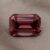 Natural emerald cut garnet gemstone on soft taupe fabric