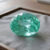 Natural oval tourmaline gemstone on soft grey jewelry display