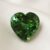 Natural heart shaped green tourmaline gemstone on soft cream fabric