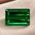 Natural emerald cut green tourmaline gemstone on beige jewelry display
