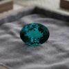 Natural blue Tourmaline oval cut gemstone on grey velvet