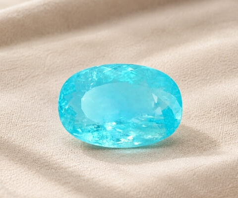 Natural Paraiba Tourmaline oval cut turquoise blue gemstone on ivory fabric