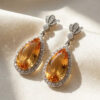 Pear Yellow Topaz and Diamond Drop Earrings on Satin Background