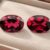 Natural Rhodolite Garnet gemstone pair with rich raspberry-red color and oval cut, front view.