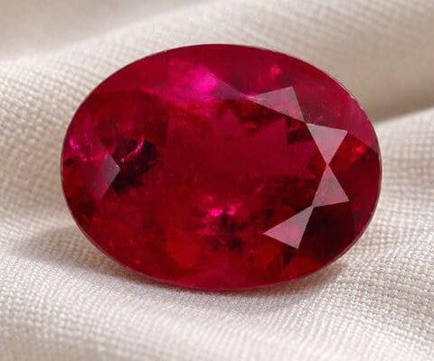 Natural Rubellite Tourmaline gemstone with vivid raspberry-red color and oval cut, front view.
