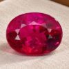 Natural Rubellite Tourmaline gemstone with vivid pinkish-red color and oval cut, front view.