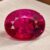 Natural Rubellite Tourmaline gemstone with vivid pinkish-red color and oval cut, front view.