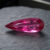Natural Rubellite Tourmaline gemstone with vibrant raspberry-pink color and pear cut, angled view.