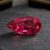 Natural Rubellite Tourmaline gemstone with vibrant raspberry-red color and pear cut, angled view.