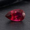 Natural Rubellite Tourmaline gemstone with deep raspberry-red color and pear cut, angled view.