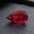 Natural Rubellite Tourmaline gemstone with deep raspberry-red color and pear cut, angled view.