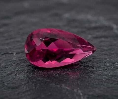 Natural Rubellite Tourmaline gemstone with vibrant raspberry-pink color and pear cut, front view.